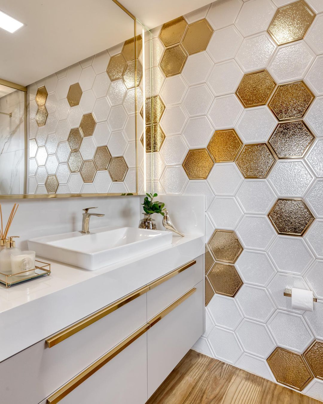 banheiro com revestimento em detalhes dourados