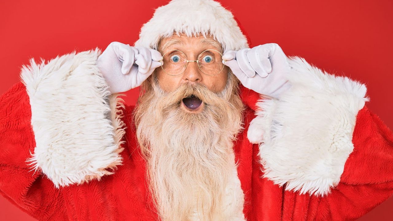 homem vestido de papai noel com rosto surpreso
